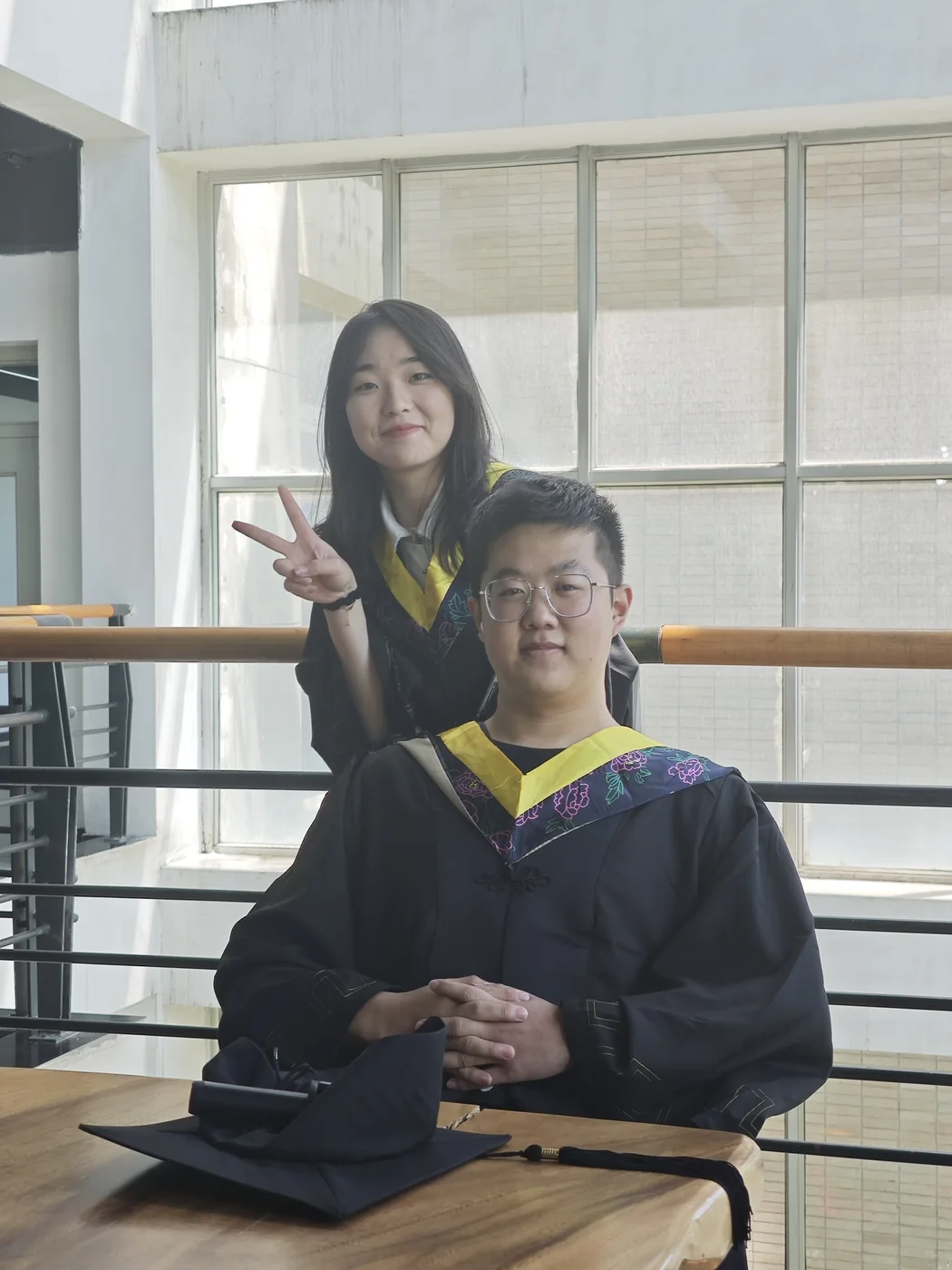 第五幕:两位朋友身穿毕业服合影